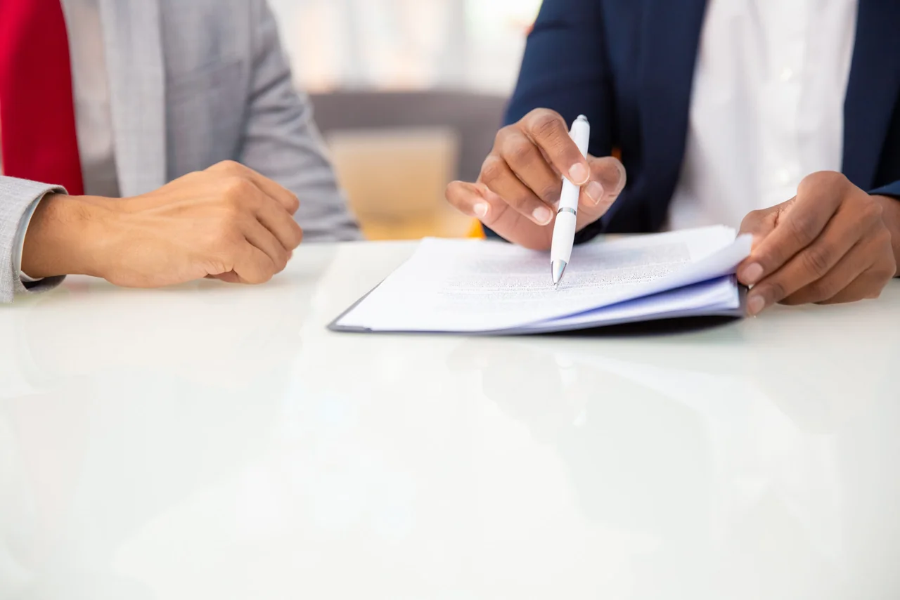 Entrepreneurs lisant et signant un contrat de création d'entreprise